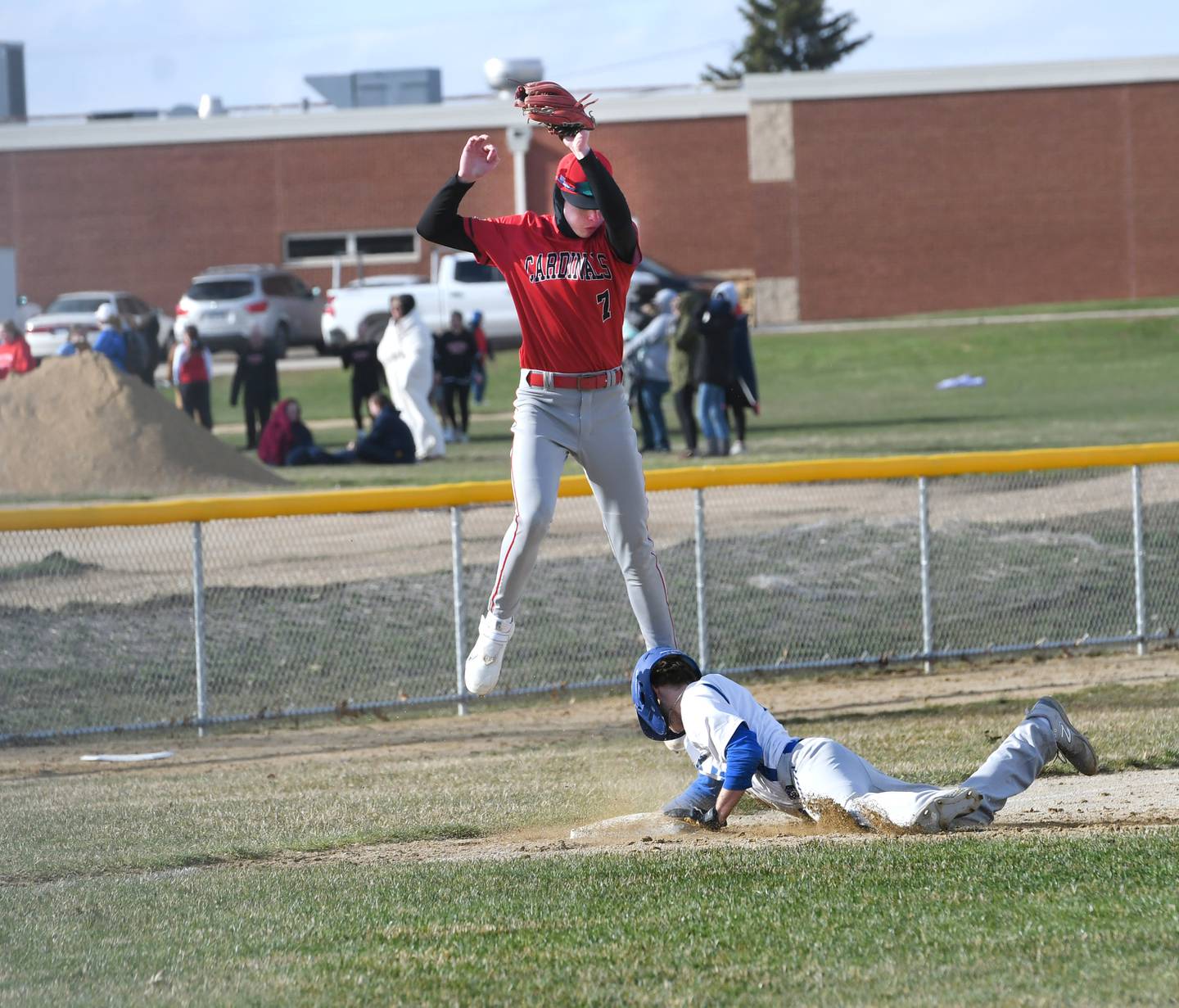 Newman's Nolan Britt slides safely into third base as Forreston's Brendan Greenfield jumps to catch a high throw during a Wednesday, April 5 game in Forreston.