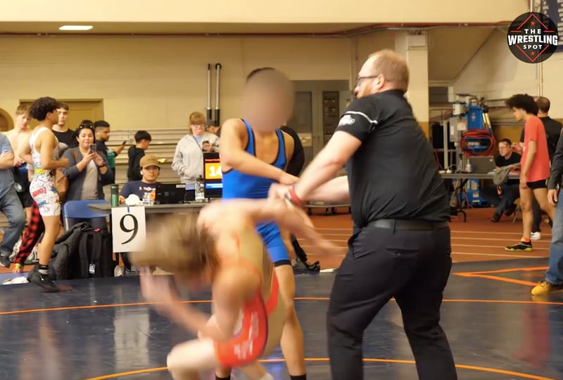 A still image taken from a video of a teenage wrestler punching another in the face after losing a match to him during a meet on April 8 at Oak Park-River Forest High School. (Courtesy of The Wrestling Spot)