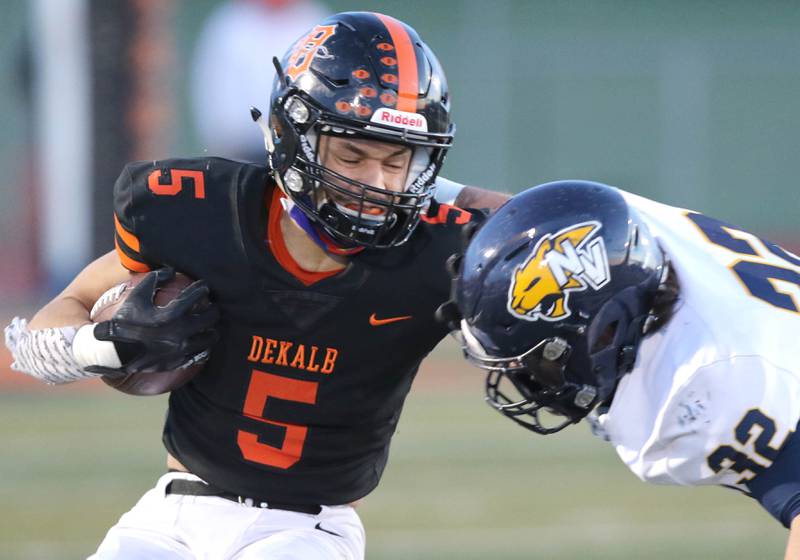 DeKalb running back Toriano Tate absorbs a hit from Neuqua Valley's Cole Dutkovich during their game Friday night at DeKalb High School.