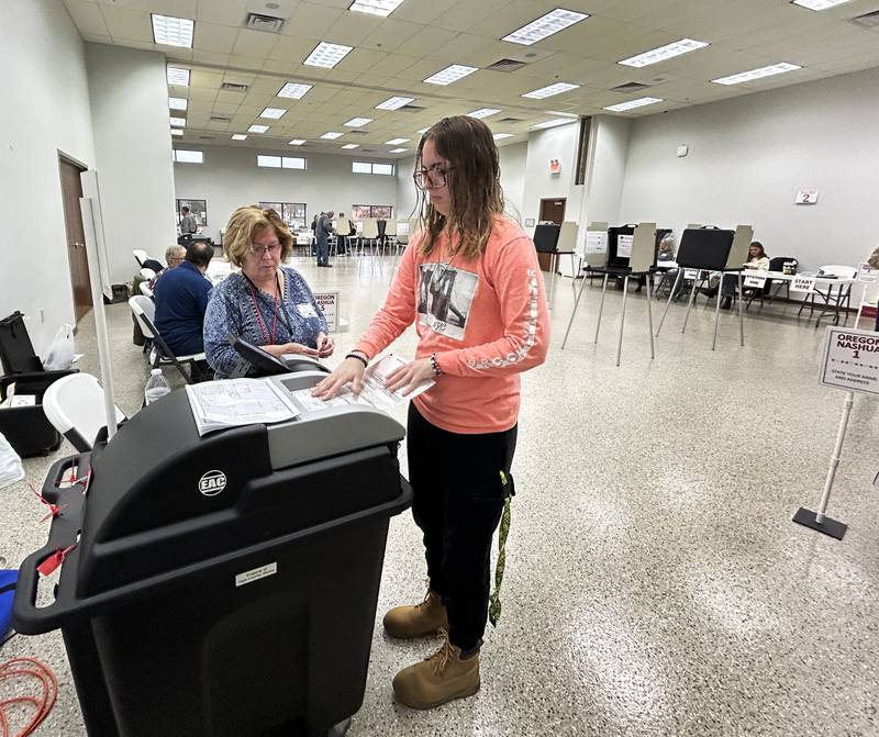 Sierra Groons guides her ballot through the counter as Election Judge Denise Bolhous watches at the Rock River Center in Oregon on Tuesday, Nov. 5, 2024.