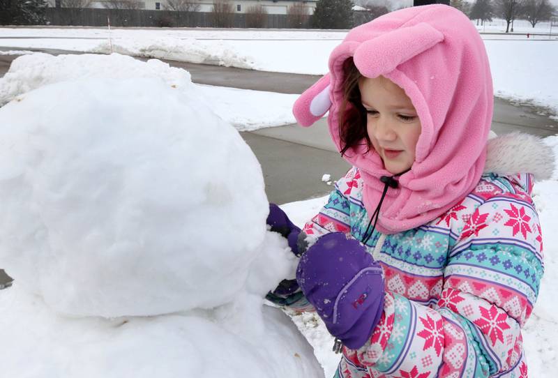 Kellyn Bradley, 5, from Sycamore, puts the finishing touches on her snowman Wednesday, Jan. 25, 2023, at the Sycamore Park District Northwestern Medicine Sled Hill.