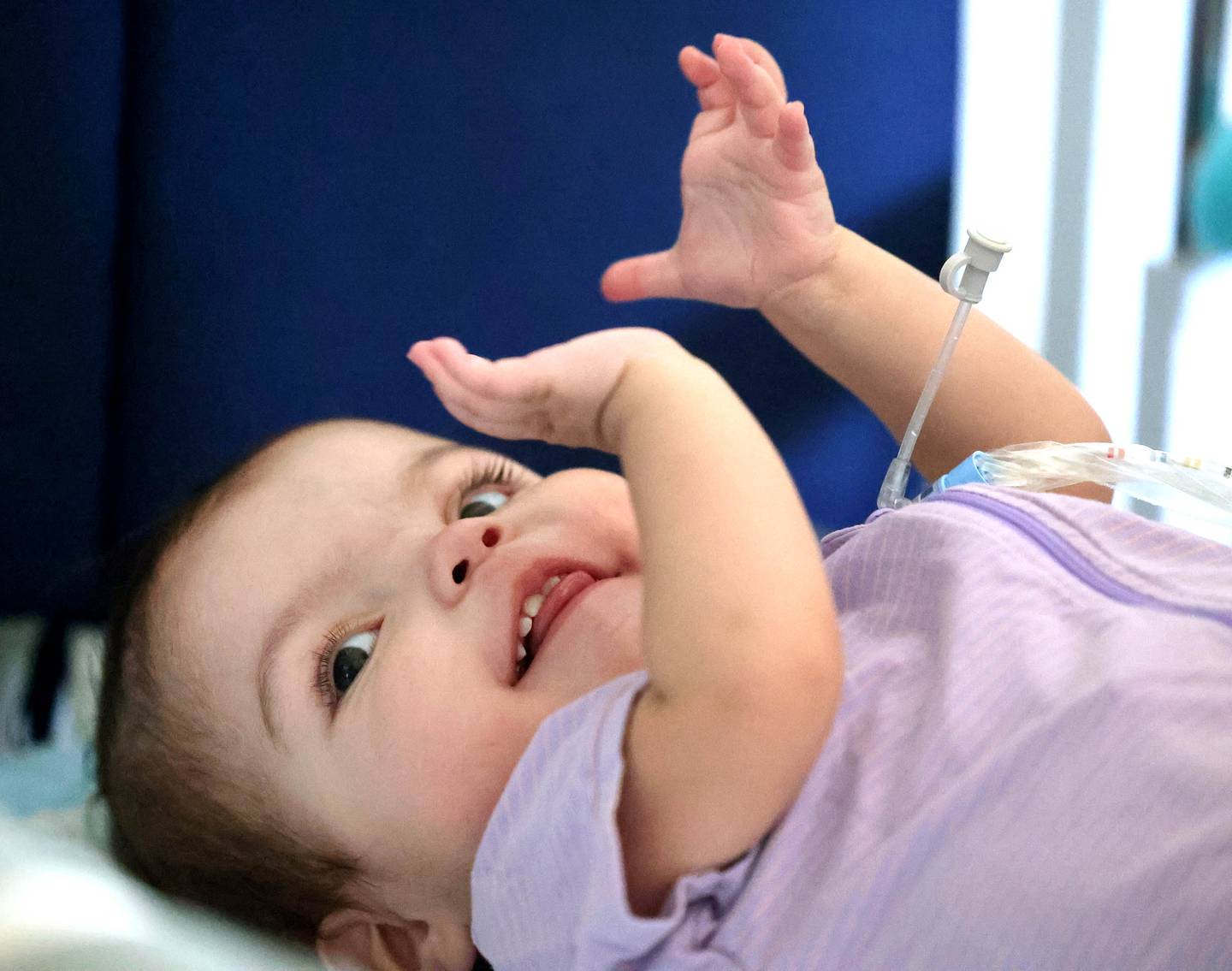 Marely Chavarria Santos, 1, claps in her crib Monday, June 30, 2025, at her home in DeKalb. Marely was born with a myriad of health issues that require around-the-clock care and recently received a heart transplant.