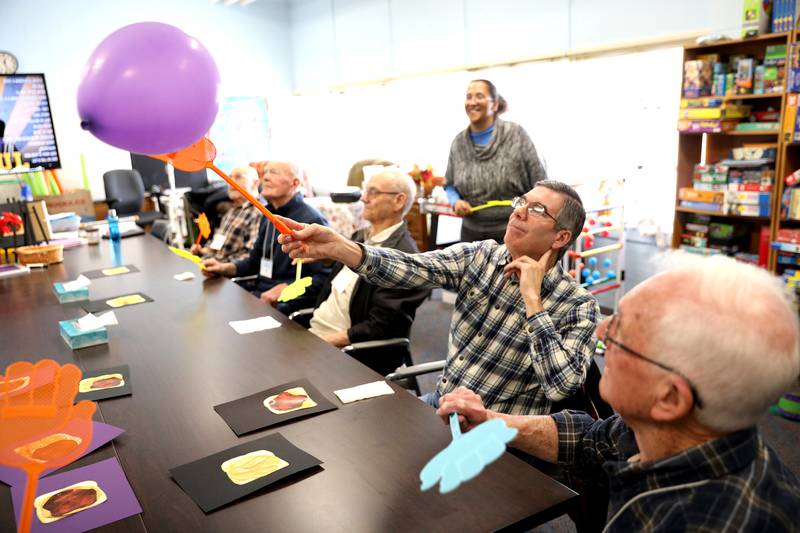 Greg C. uses a fly swatter to bat at a balloon during a program at the Elderday Center in Batavia. The center, which offers therapeutic care for seniors will celebrate 35 years of service this year.