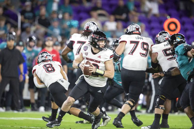 Coastal Carolina quarterback Bryce Carpenter (12) rolls out to throw the ball against Northern Illinois during the Cure Bowl NCAA college football game in Orlando, Fla., Friday, Dec. 17, 2021.