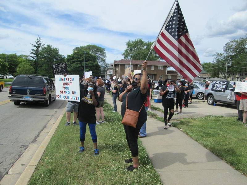 Lorraine Allen of Joliet waves an American flag at the Black Lives Matter rally on Friday.
