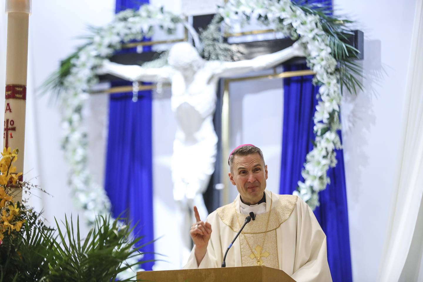 Bishop Ronald Hicks delivers communion to parishioners on Sunday, April 4, 2021, at Our Lady of Mount Carmel Parish in Joliet, Ill. The Parish held an in-person socially distant Easter service, where the Bishop delivered his sermon in Spanish.