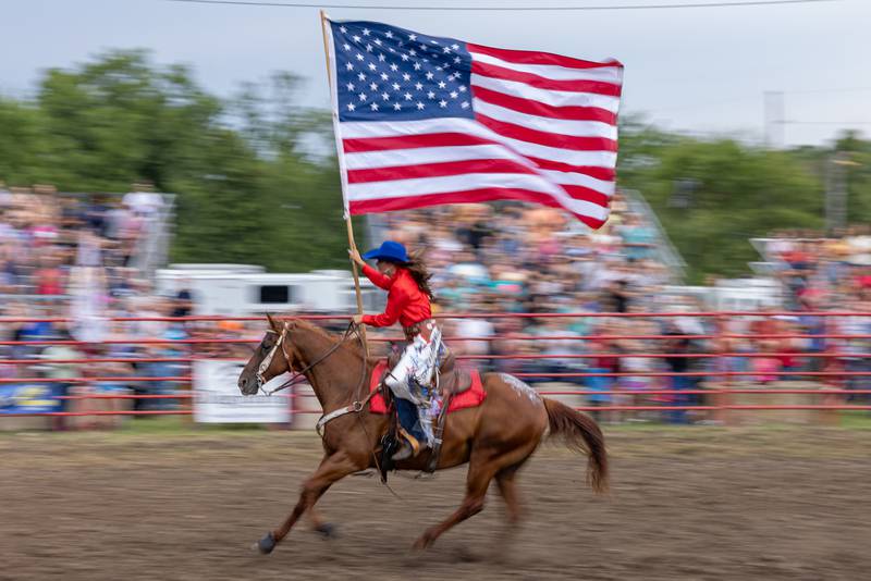 Sage McNeil displays the American flag as her horse sprints through the arena during the rodeo at the LaSalle County 4H Fair on July 11, 2025 in Ottawa.