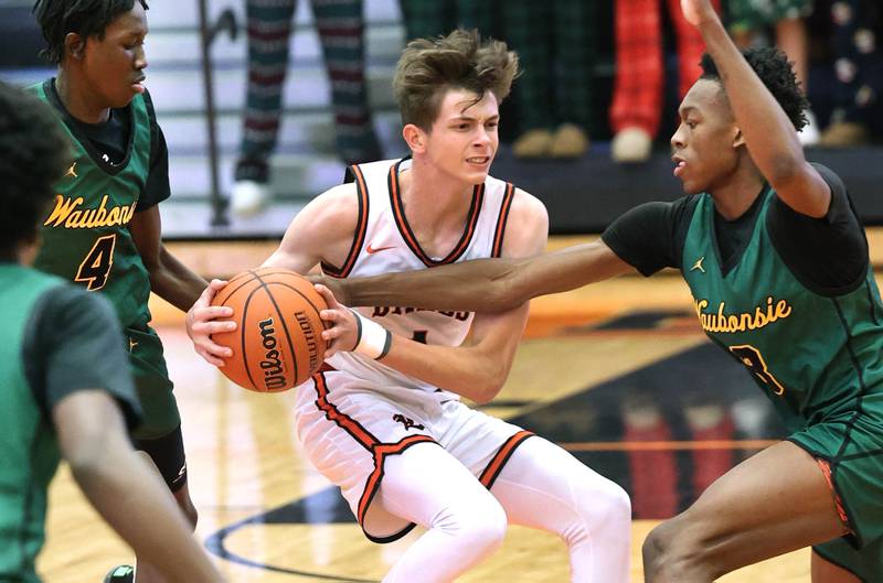 DeKalb’s Jackson Kees is surrounded by Waubonsie Valley's Moses Wilson (left) and Tre Blissett during their game Friday, Dec. 15, 2023, at DeKalb High School.