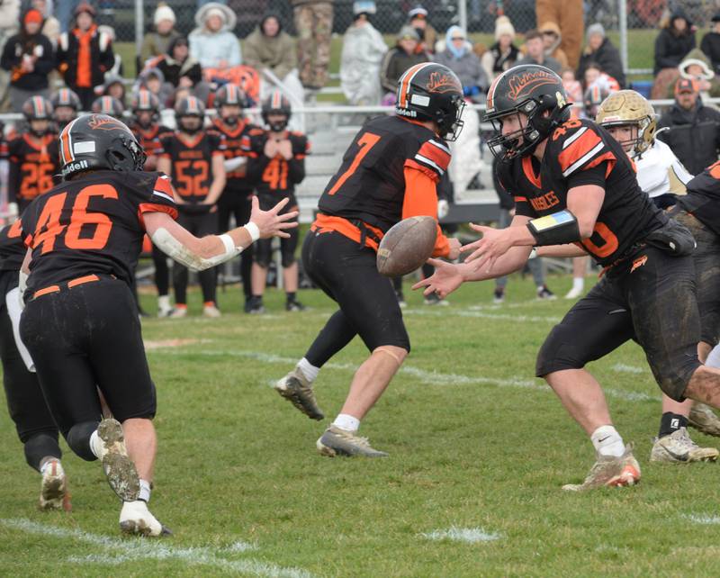 Milledgeville's Karter Livengood (48) tosses the ball to Spencer Nye (46) during 8-man playoff action against Polo on Saturday, Nov. 16, 2024 at Milledgeville.