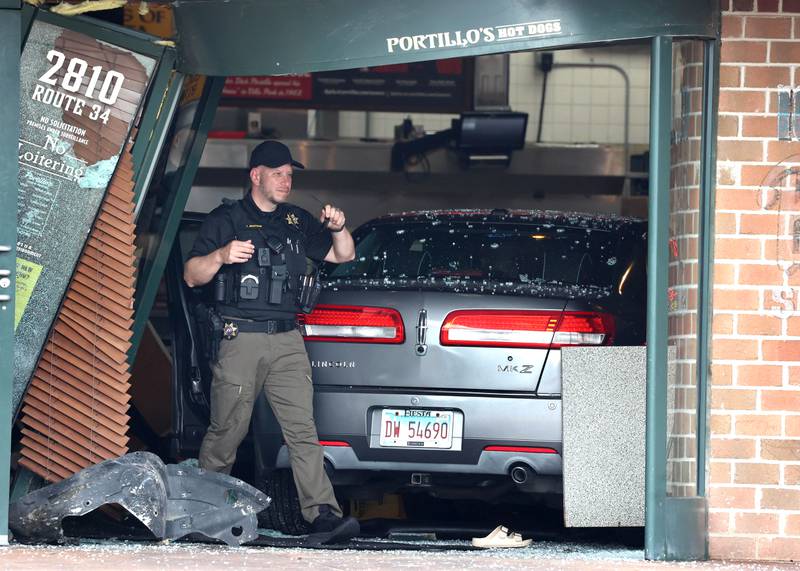 A member of law enforcement exits the Portillo’s Wednesday, July 30, 2025, after a car crashed through the front entrance of the business at 2810 U.S. Route 34 in Oswego injuring 12.