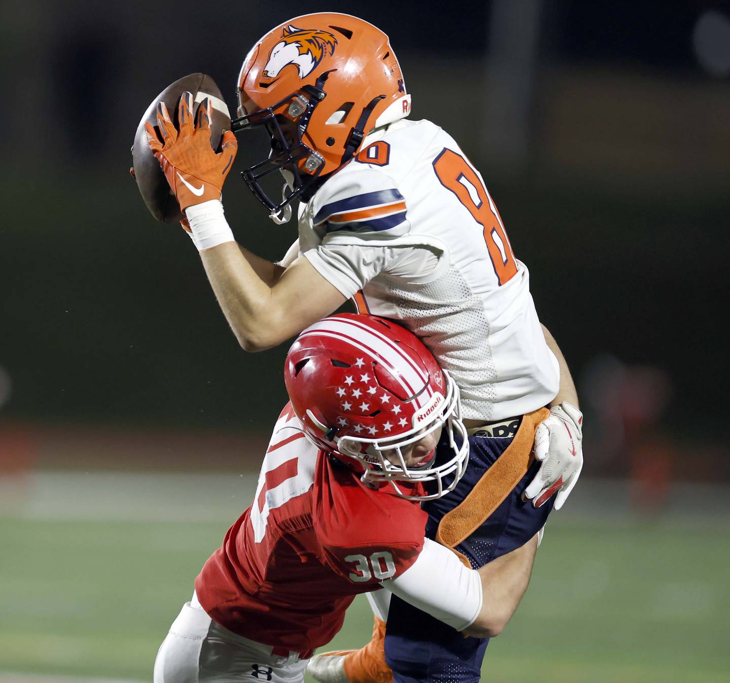 Naperville Central's Andrew Applegate (30) wraps up Naperville North's Gabriel Hill (8) Friday, Oct. 24, 2025 at North Central College in Naperville.