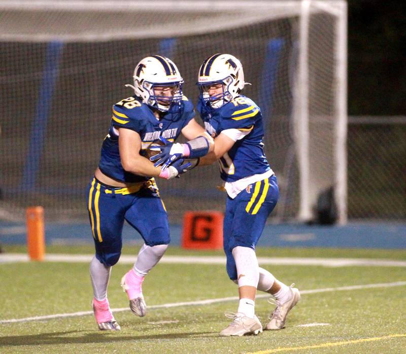 Wheaton North quarterback Nick Johnson hands the ball off to Max Serbick during a game against Batavia on Friday, Sept. 27, 2024 at Wheaton North.