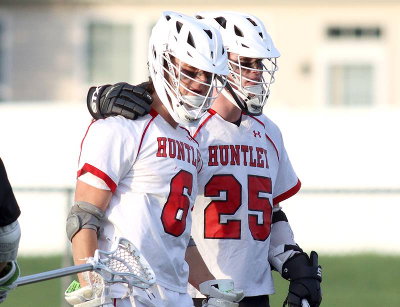 Huntley’s Justin Jacobsen, left, is greeted by teammate Joshua Witt after Jacobsen scored against Hampshire in varsity lacrosse at Huntley Thursday night.
