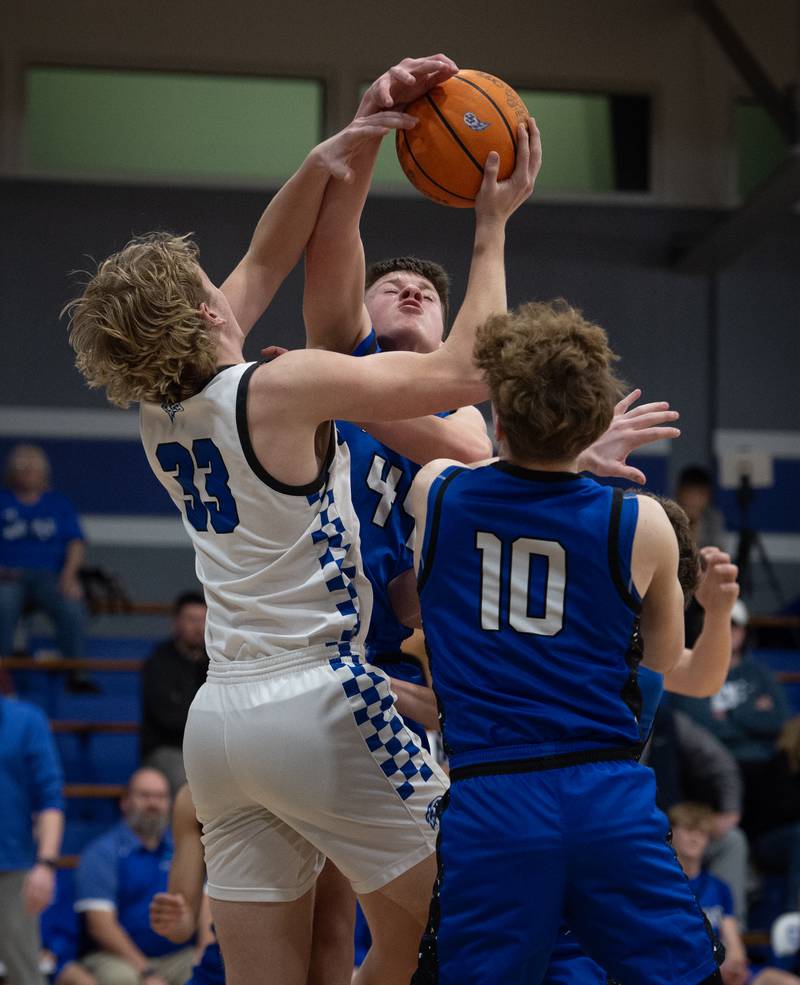 Milford's Jack VanHoveln, back, and Aiden Frerichs, front try to grab a rebound over Clifton Central's Jake Thompson, left, during a Class A Regional game on Monday, Feb. 23, 2026.