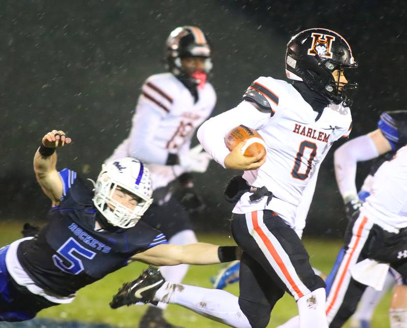 Burlington Central’s Parker Auxier, left, reaches for Harlem’s Lebron McClelland in IHSA football Class 6A second-round playoff action at Central High School in Burlington on Saturday, November 8, 2025.