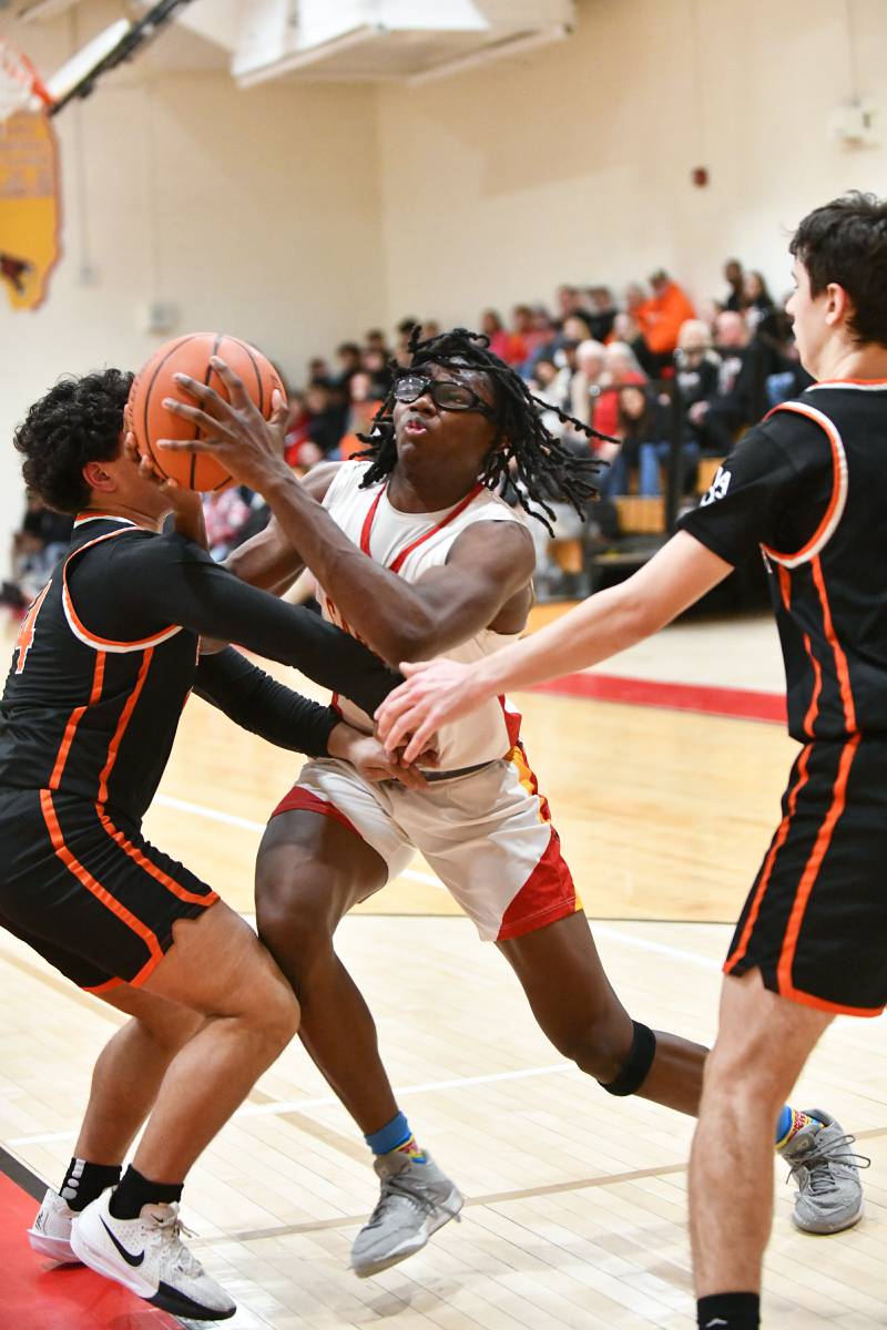 St. Anne's Chris Link drives to the hoop against Beecher defenders on Friday, Feb. 14, 2025, during the Cardinals' 70-38 victory over Beecher in the River Valley Conference championship.