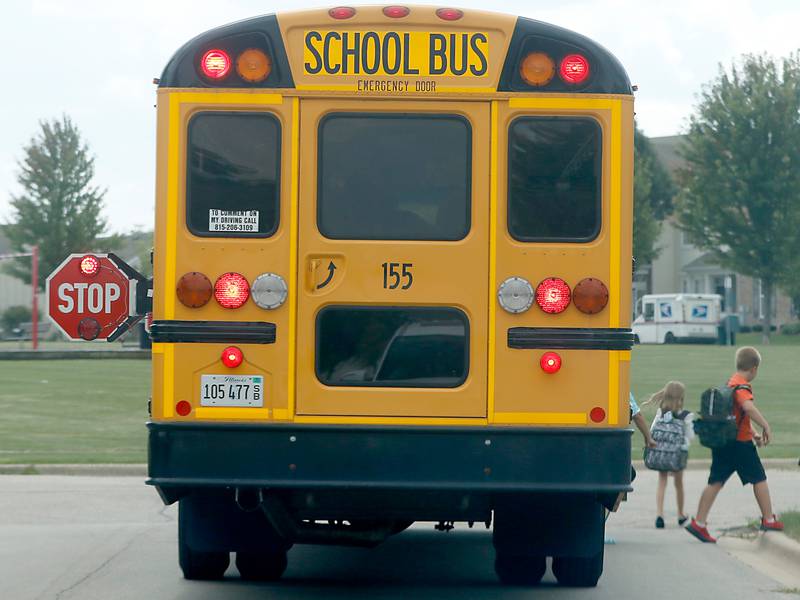 Children get off a stopped Woodstock school bus on Sweetwater Drive in Woodstock on Thursday, Aug. 17, 2023.