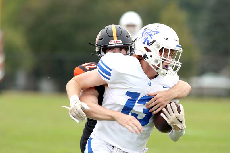 Burlington Central’s Michael Person is wrapped up from behind by Crystal Lake Central’s Tyler Porter in varsity football at Crystal Lake Saturday.