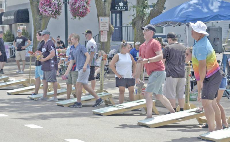 Contestants toss bags during the bags tournament Saturday, July 5, at the 61st annual Dixon Petunia Fest.