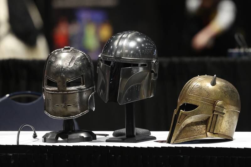 Cosplay helmets from Iron Man and the Mandalorian series sit on a table before the start of a cosplay workshop at C2E2 Chicago Comic & Entertainment Expo on Sunday, April 2, 2023 at McCormick Place in Chicago.