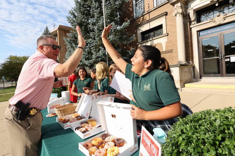 Kankakee County Undersheriff Chad Gessner high fives Bishop McNamara Catholic School fifth graders, all members of the student council, as they host the 10th Gratitude Drive-Thru for first responders and military members on Thursday, Sept. 11, 2025.