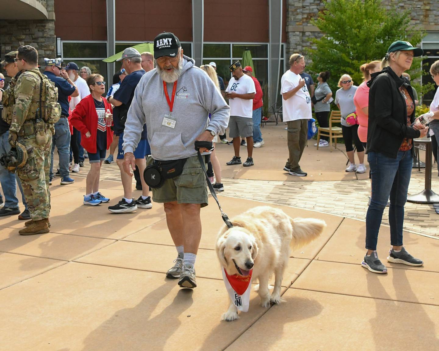 Dick Hilderbrant and his golden retriever Joey of nonprofit Canines 4 Christ walk around and greet people before the start of the second annual Be the One Walk to end veteran suicide on Sunday, Sept. 21, 2025, held at Northwestern Medicine Kishwaukee Health & Wellness Center in DeKalb.