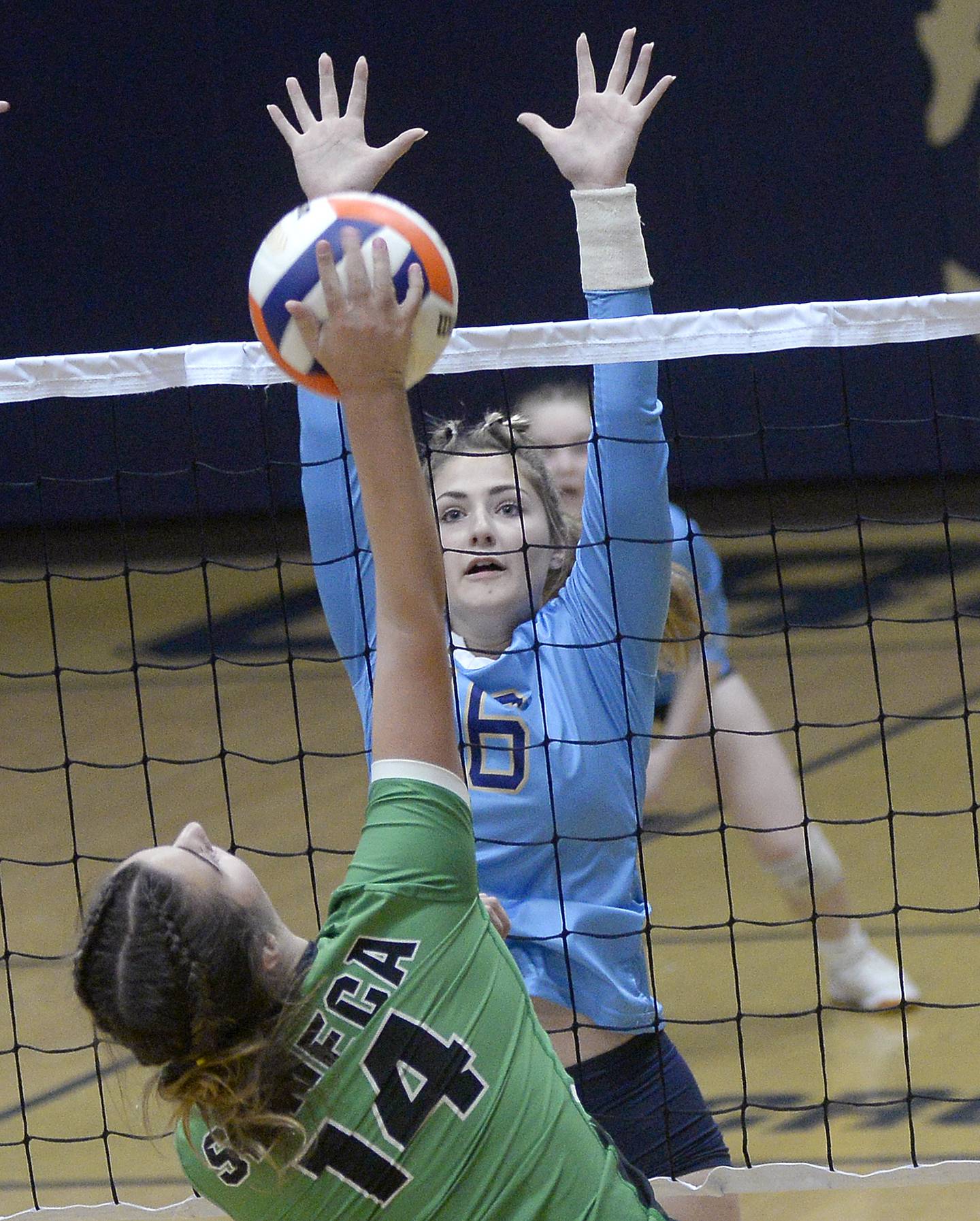 Seneca's Sophie Cato (14) strikes the ball as Marquette's Laren Macheta eyes a block Thursday, Sept. 1, 2022, in Ottawa.