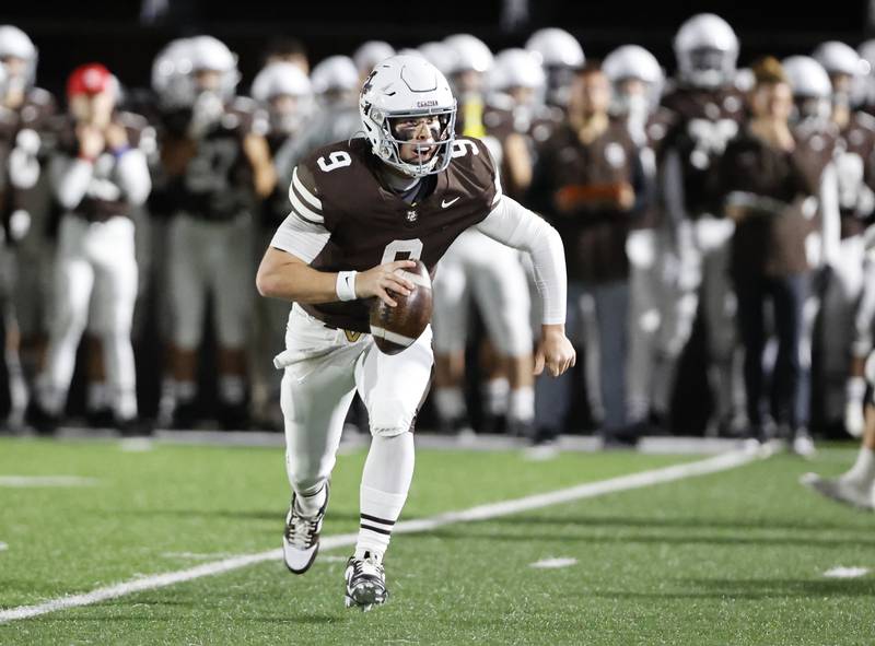 Mt. Carmel's Jack Elliott (9) scrambles looking for a receiver during the varsity football game between Loyola Academy and Mt. Carmel high school on Friday, Oct. 25, 2024 in Chicago.