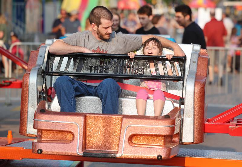 Rylee Mattea, 5, from Genoa, is just tall enough to get on the ride with Jon Grimm, also from Genoa, at Genoa Days, Wednesday, June 7, 2023, in downtown Genoa. The festival continues through Saturday.