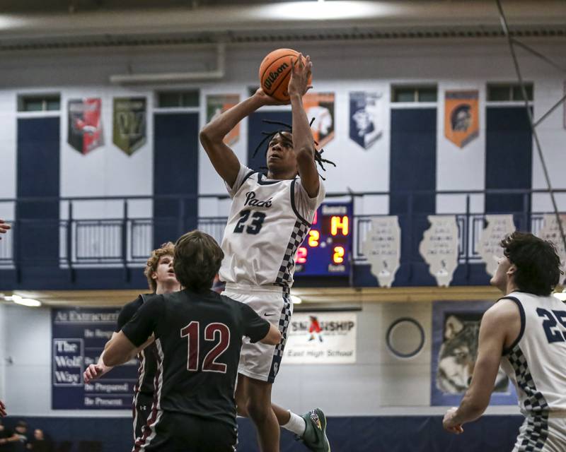 Oswego East's Mason Lockett IV (23) puts up a shot over the defense during their basketball game between Plainfield North at Oswego East Friday, Dec 5, 2025 in Oswego.