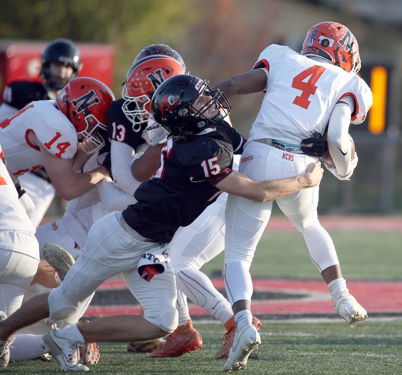 Glenbard East's Dylan Novak (15) wraps up Normal's Tommy Davis (4) during the IHSA Class 7A quarterfinals Saturday November 11, 2023 in Lombard.