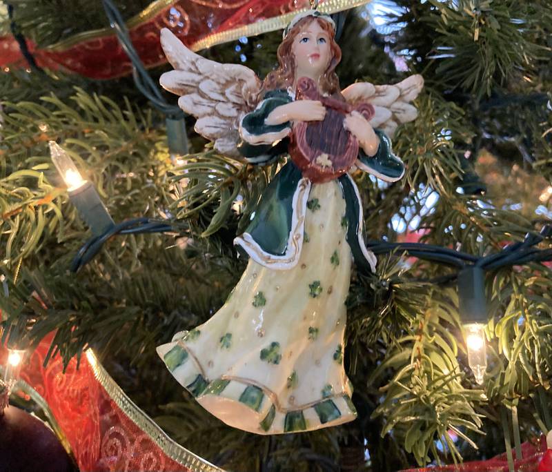 A hand-painted ornament hangs on a Christmas tree.