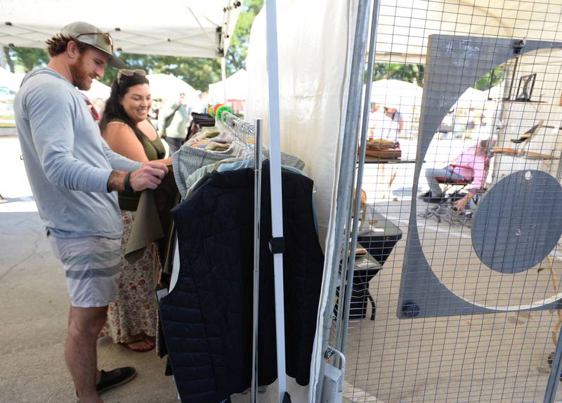 Rusty and Kristina Webster of La Grange Park look over some of the clothes sold at Jack's West End during the LaGrange Art Festival Saturday, Sept. 9, 2023.