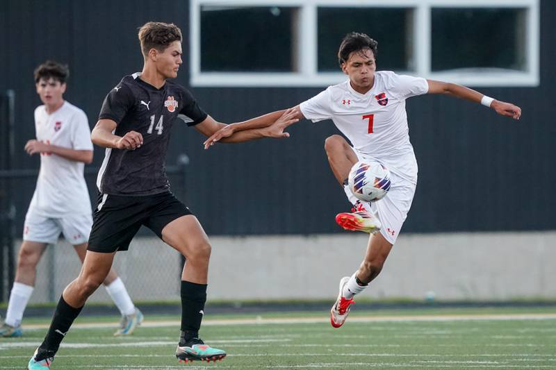 Oswego’s Enrique Castaneda (7) plays the ball against Wheaton Warrenville South's Tyler Luetkehans (14) during a soccer match at Wheaton Warrenville South in Wheaton on Thursday, Aug 28, 2025.