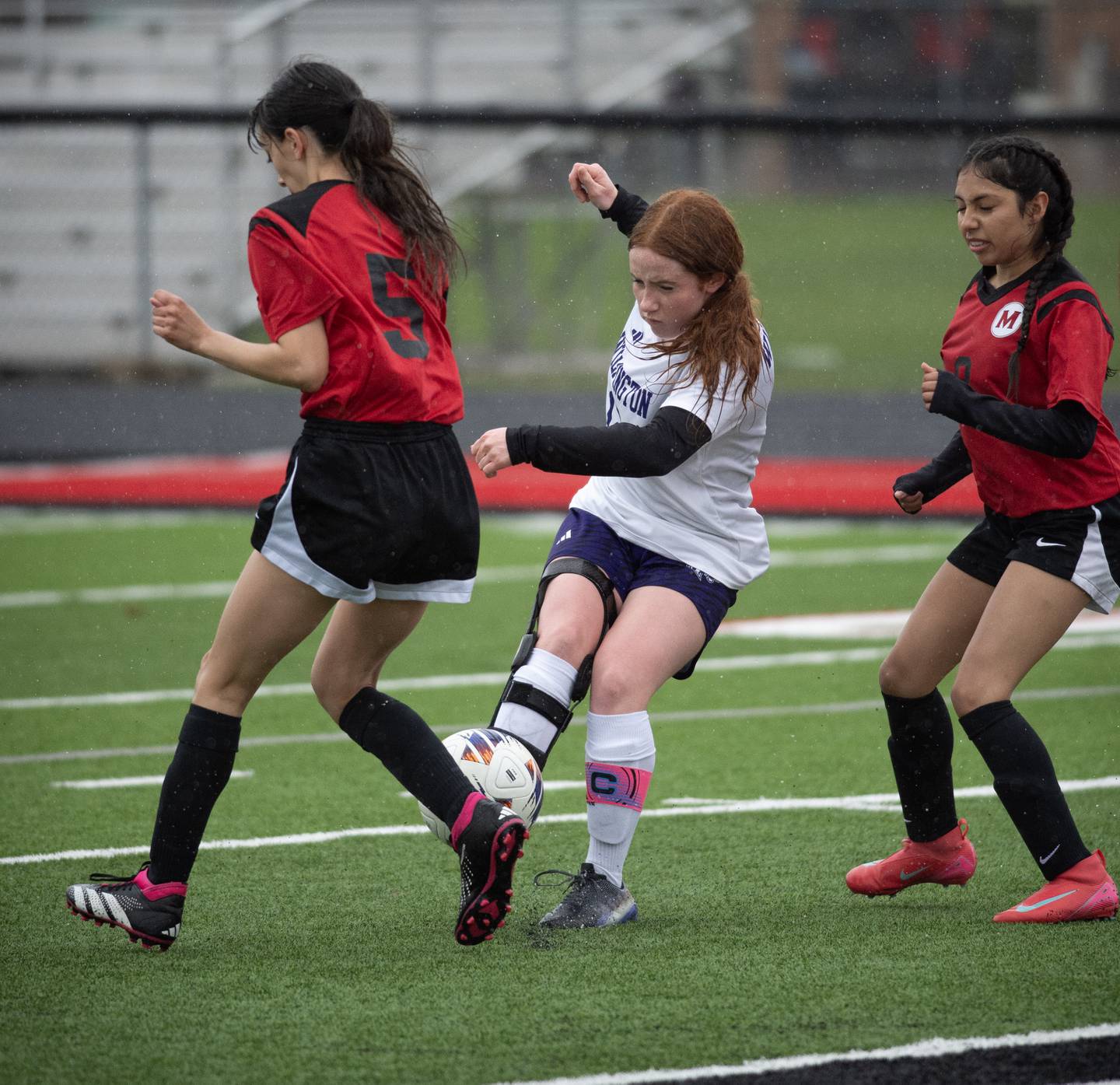 Wilmington's Hannah Basinger, center, takes a shot on goal as Momence's Brittany Gomez, left, and Aden Garcia, right, defend during the game in Momence on April 4, 2025.