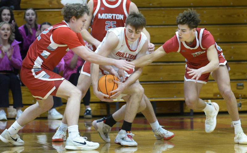 Moton’s Wes Gudeman and Silas Steffen battle with Streator’s Nolan Lukach for a loose ball in the 1st period Wednesday at Streator.