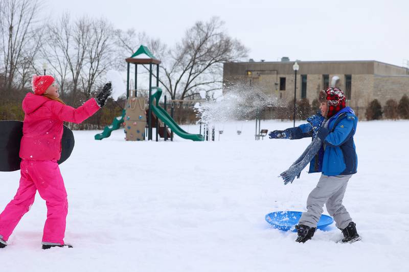 Anna Senesac, 11, left, and friend Declan Cross, 11, both of Bradley, exchange throws of snow after sledding to the bottom of Helgeson Park in Bradley on Sunday, Nov. 30, 2025.