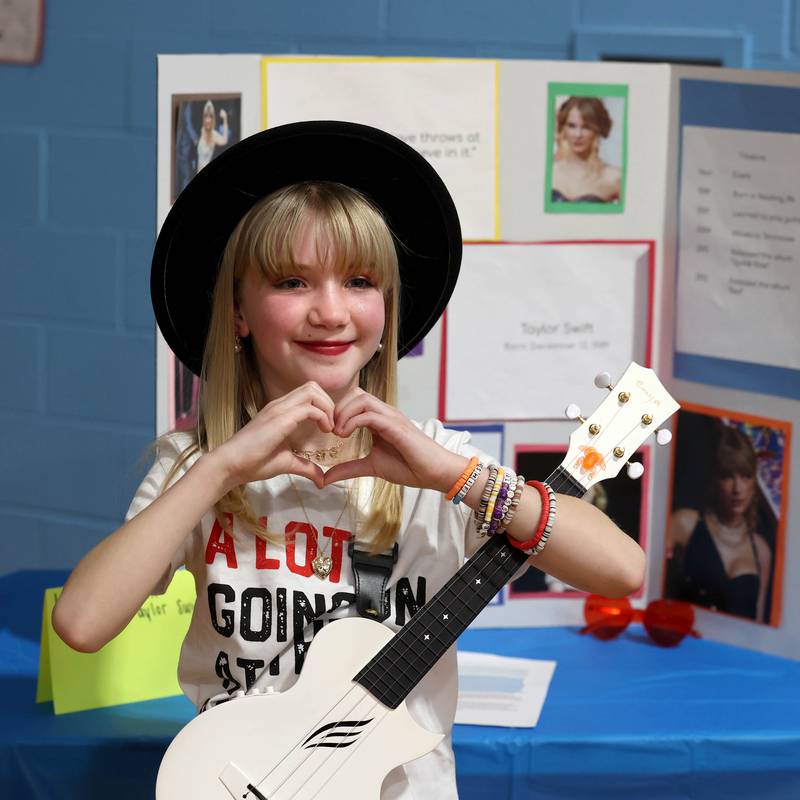 Third grader Lydia Petritsch, portraying Taylor Swift, waits for someone to press the button to activate her speech during the Hinckley Big Rock Elementary School Wax Museum Thursday, March 13, 2025, at the school in Hinckley.