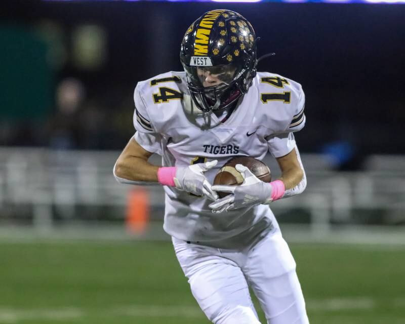 Joliet West's Payton Turner (14) gathers in a pass reception during football game between Joliet West at Plainfield Central.   Oct 20, 2023.