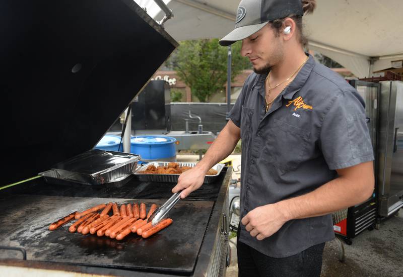 Alex Locascio of Downers Grove grills hot dogs, brats and chicken during the Downers Grove Octoberfest Saturday, Sept. 16, 2023.