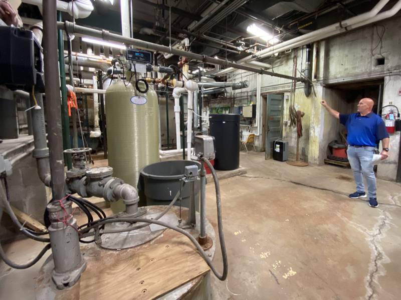 Mark Walker explains the flooding issues in the boiler room at Morris Community High School.