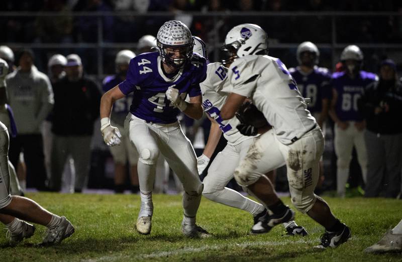 Wilmington's Declan Moran, center left, zones in on El Paso-Gridley's Aaden Adams, right, as he carries the ball in the Class 2A semifinal on Saturday, November 22, 2025.