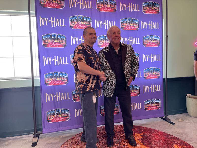 Jarrett Lopez, left, takes a photo with wrestling icon Ric Flair, right, on Saturday, April 15, 2023, at Ivy Hall Dispenary in Crystal Lake. Flair was in attendance to both meet fans and promote a new line of marijuana products, "Ric Flair Drip."