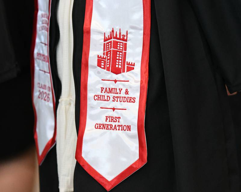 A Northern Illinois University graduate wears a stole showing their major and first generation for graduation on Saturday May 9, 2026, held at the Convocation Center in DeKalb.