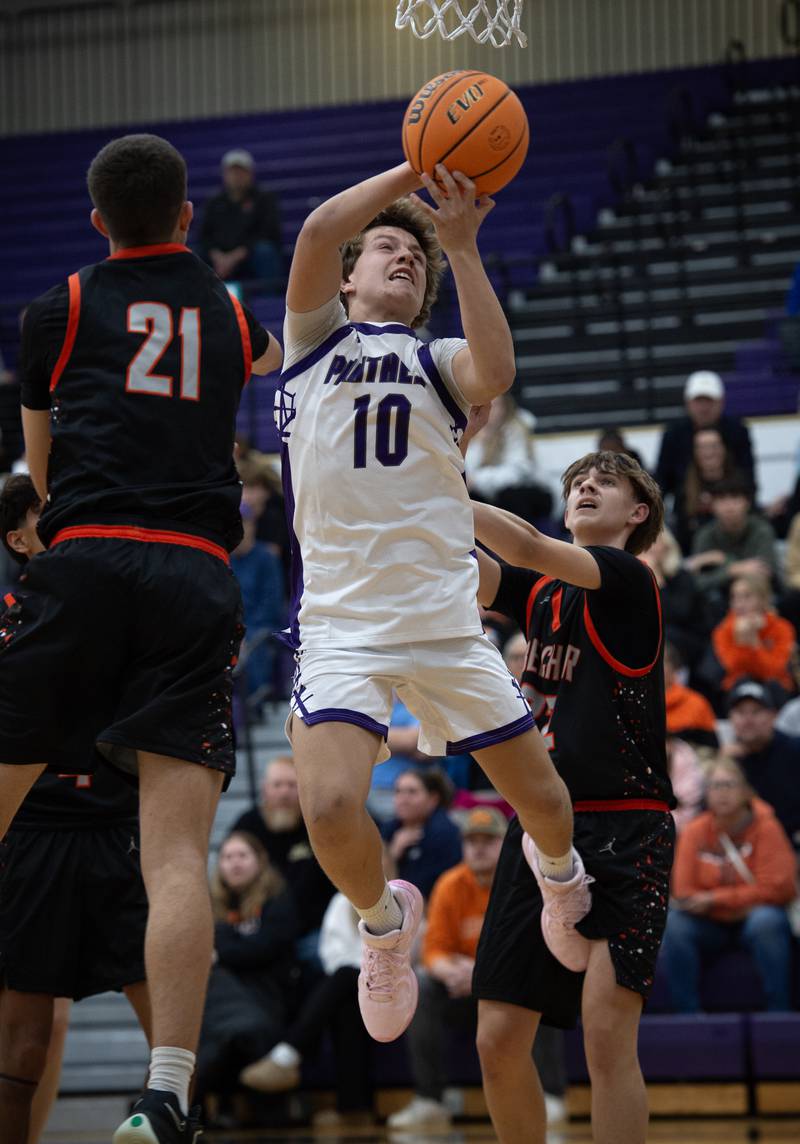Manteno's Jack Gotkowski, center, elevates for a shot as Beecher's Michael DeFrank, left, and Wesley Haddon, right, defend in the Thanksgiving tournament at Manteno High School on Monday, November 24, 2025.