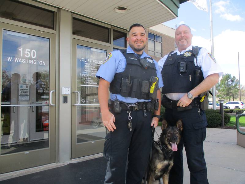 Joliet Police Department K-9 Officer Adam Rosales (left) and Sgt. Bill Otis join police dog Aro for a photo.