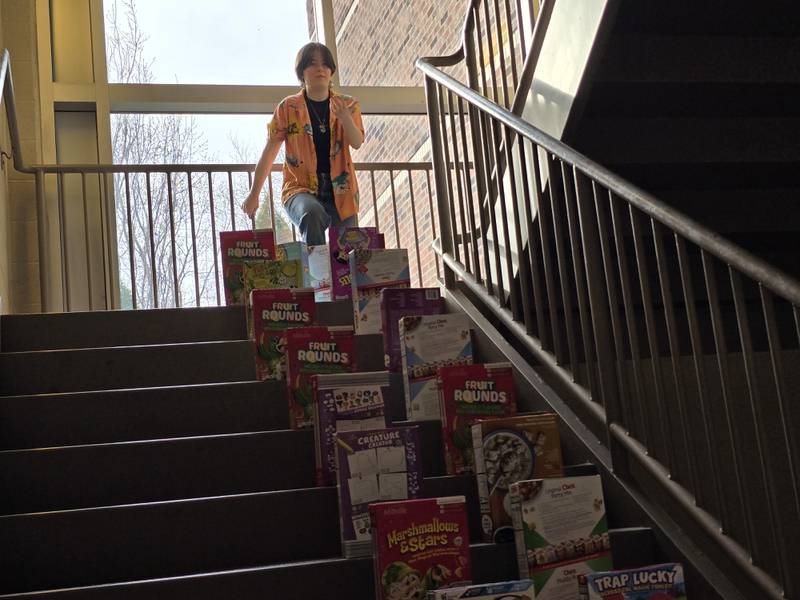 Destany Krebsbach kicks off Streator FFA's cereal box dominoes on Tuesday, March 18, 2025, at the top of the stairs in Streator High School.