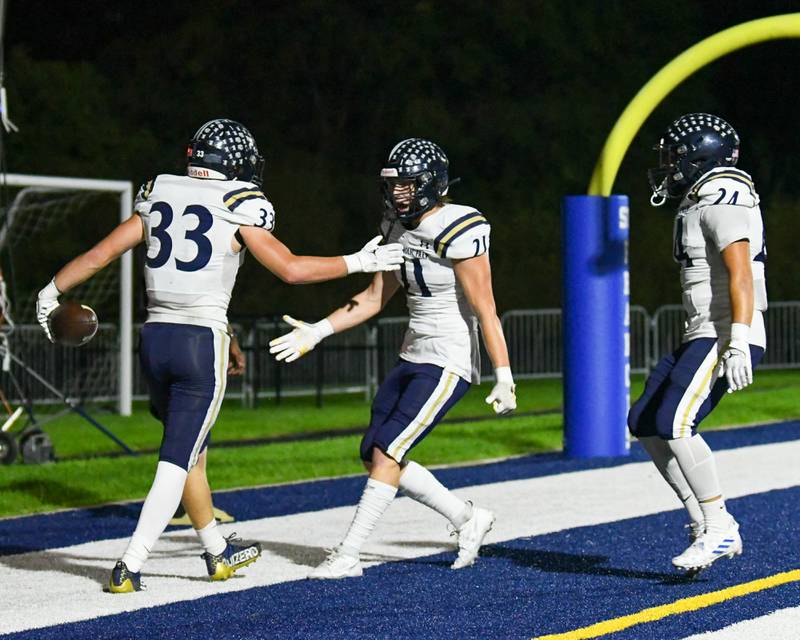 IC Catholic Prep Joey Glatta (33) celebrates with teammate Dennis Mandala, center, after Joey scores a touchdown in the first quarter while taking on St. Francis in Wheaton on Friday Sep. 29, 2023.