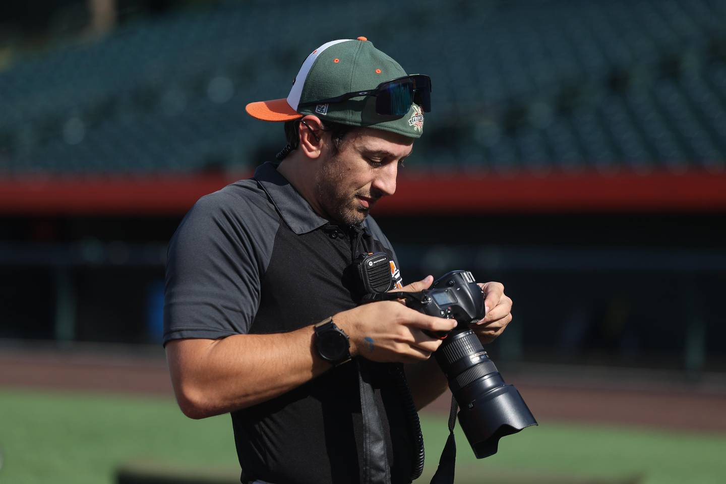 Adam Jomant looks over his Joliet Slammers team photos on Friday, August 23, 2024 in Joliet. Aside from his 9 to 5 job, Adam is a freelancer photographer, a DJ, volunteers with the Emergency Medical Services, part of a storm chasing crew and is an avid hiker.