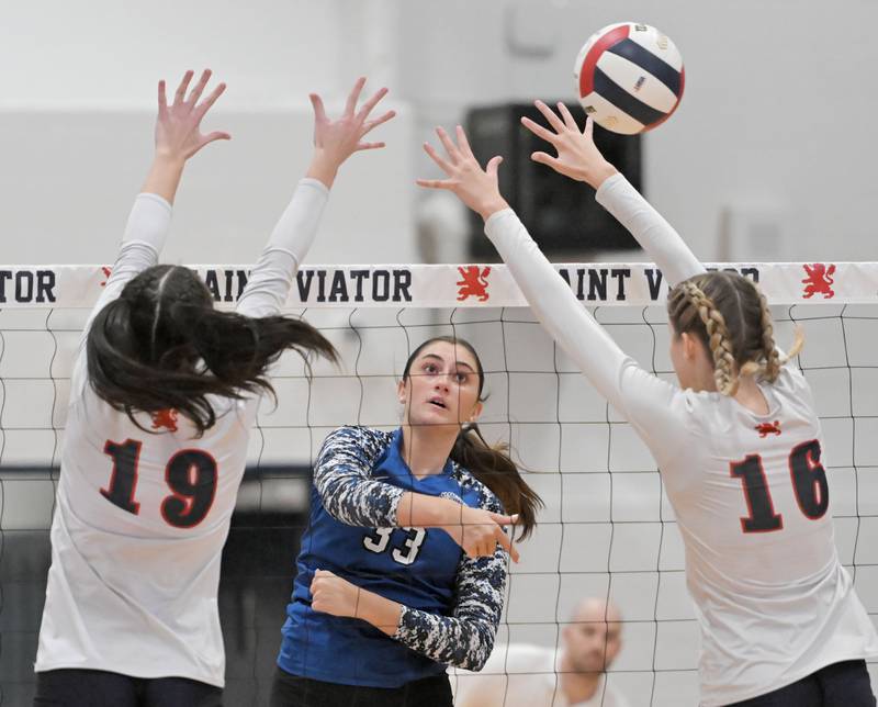 St. Francis’ Emma Delaney gets her shot past St. Viator’s Sydney Mittel and Avery Albritton, right, in an IHSA Class 3A sectional semifinal girls volleyball game in Arlington Heights on Tuesday, Nov. 5, 2024.